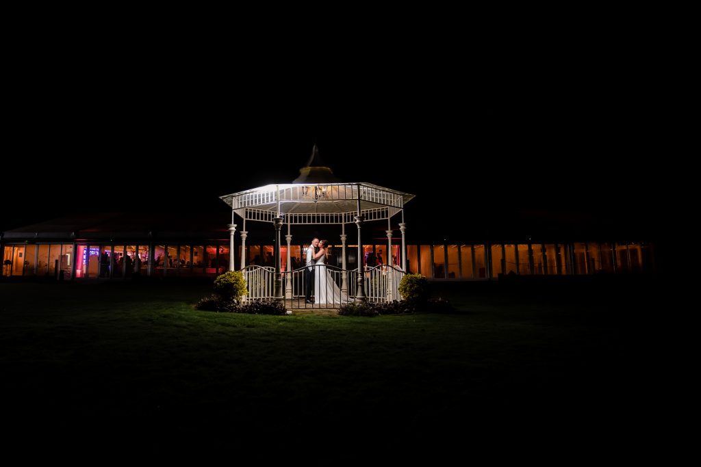 bride and groom under a pagoda at parklands quendon hall wedding venue - wedding photographer in Essex - lily and white