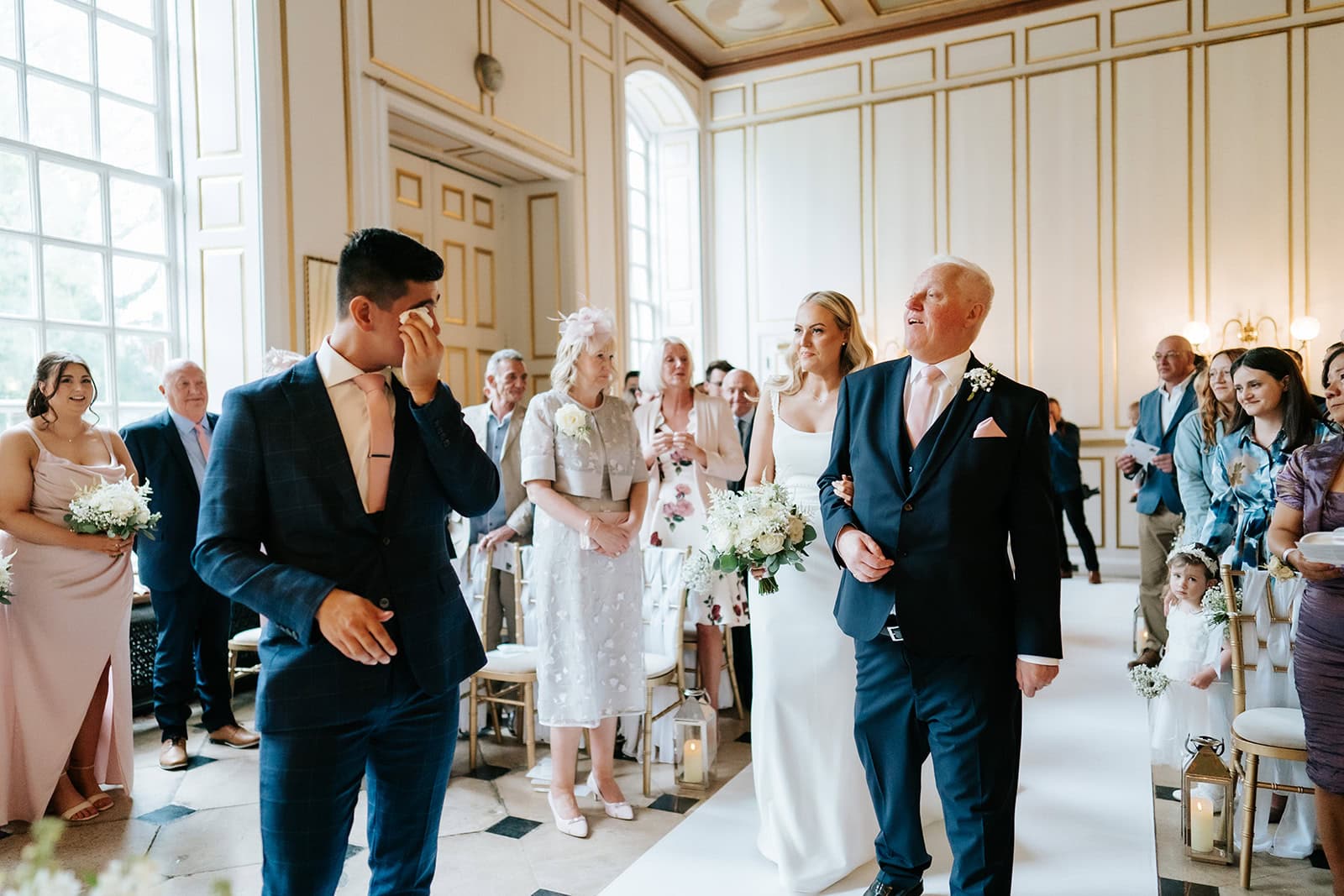 Groom wiping tears during wedding ceremony at Gosfield Hall — emotional documentary moment captured by Lily & White