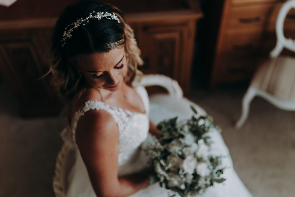 bride with her bouquet smiling for her essex wedding photography