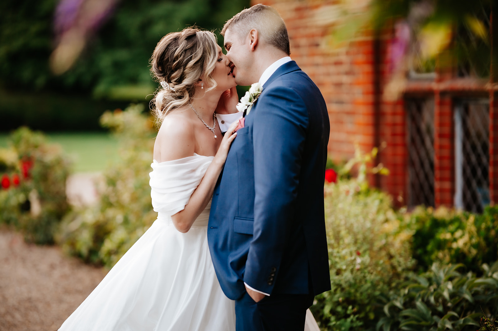 Couple share a kiss at their wedding, captured by lily and white wedding photography.