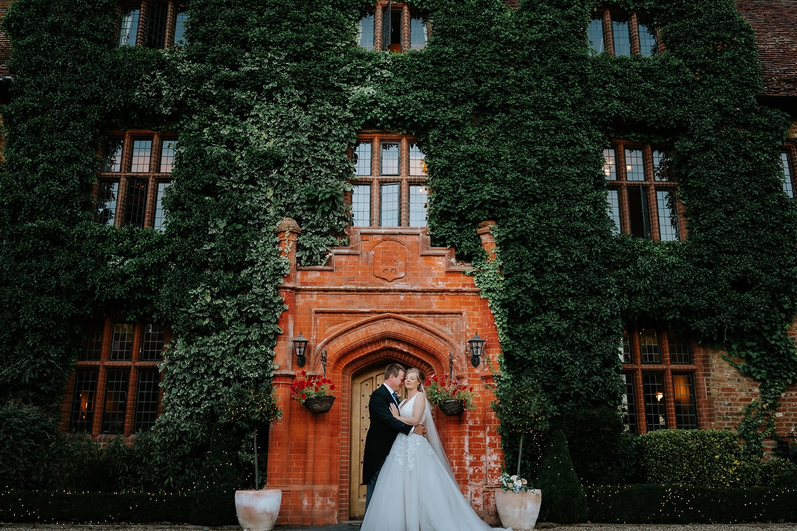 Abi and Peter in the grounds at Woodhall Manor, Suffolk, on their summer wedding day – 11th August 2022, photographed by Tel, Lily & White.